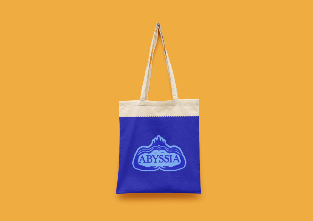 tote bag bleu avec le logo d'Abyssia sur fond jaune